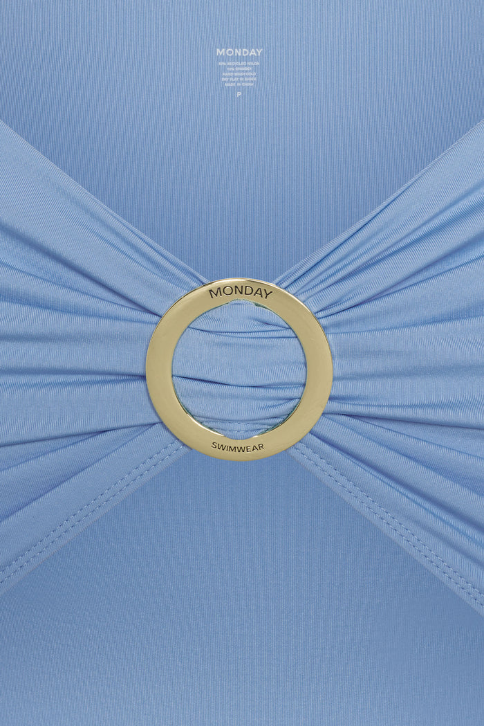 Close-up of Jamaica Sarong in Azure showing gold O-ring hardware centered with ruched light-blue stretch fabric