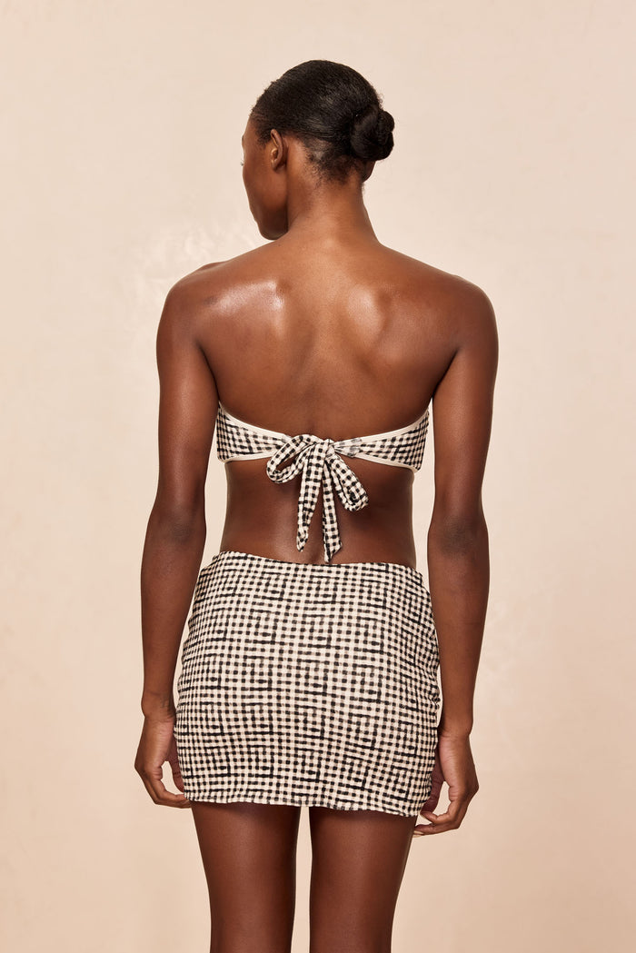 Rear view of Jamaica Sarong in black gingham showing mini length and slip-on wrap silhouette on neutral studio background