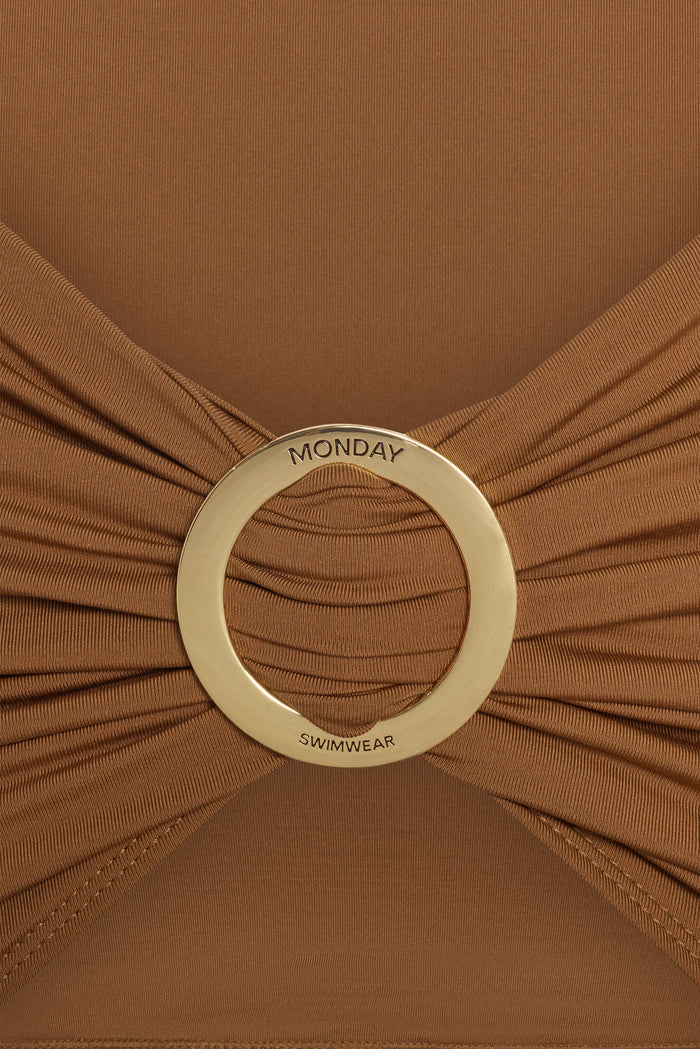 Close-up of Jamaica Sarong in caramel showcasing gold circular branded ring engraved MONDAY SWIMWEAR with ruched fabric