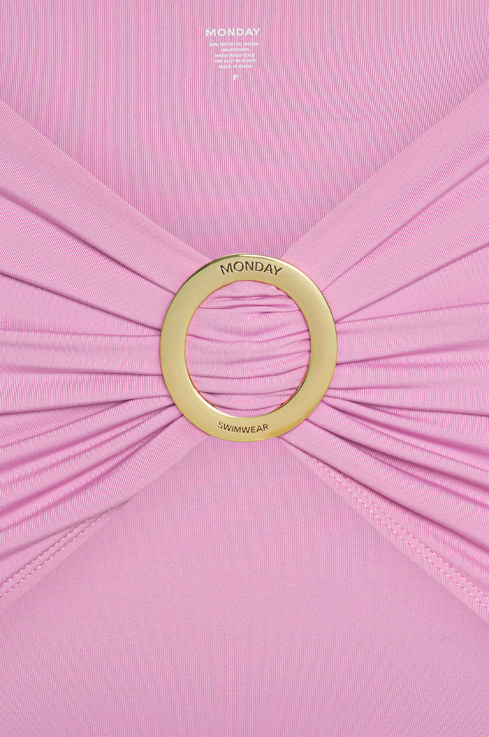 Close-up of Jamaica Sarong - Moonlight showcasing adjustable gold metal sliding buckle engraved with MONDAY on pink fabric