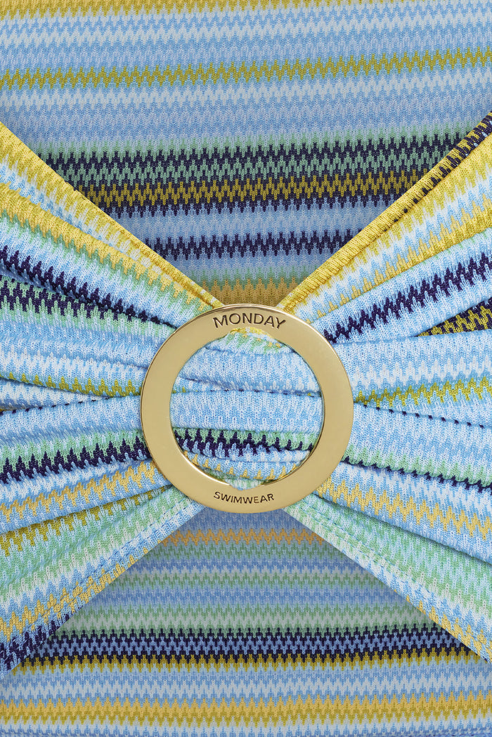 Close-up of Jamaica Sarong sash with gold circular buckle engraved MONDAY SWIMWEAR on Sardinia Stripe Azure striped knit fabric