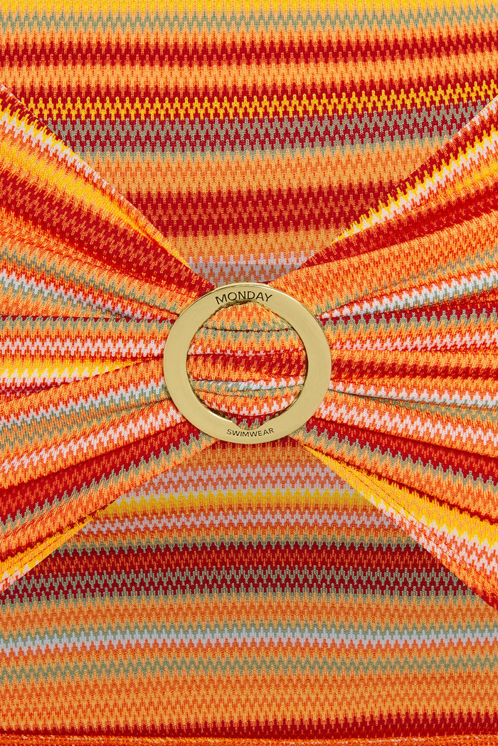 Close-up of Jamaica Sarong Sardinia Stripe showcasing gold MONDAY SWIMWEAR ring and orange-red striped knit