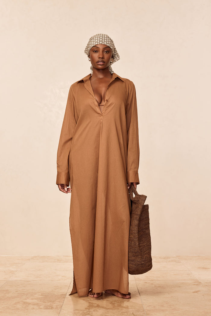 Front view of Kokomo Kaftan in caramel showing deep V neckline, long relaxed maxi fit and long sleeves on a model against a neutral beige background