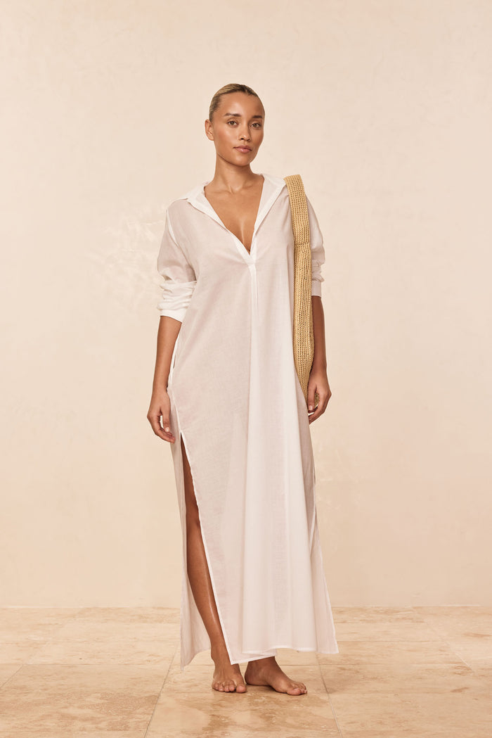 Front view of Kokomo kaftan in white cotton voile showing V-neck, high side slit and rolled sleeves on neutral background