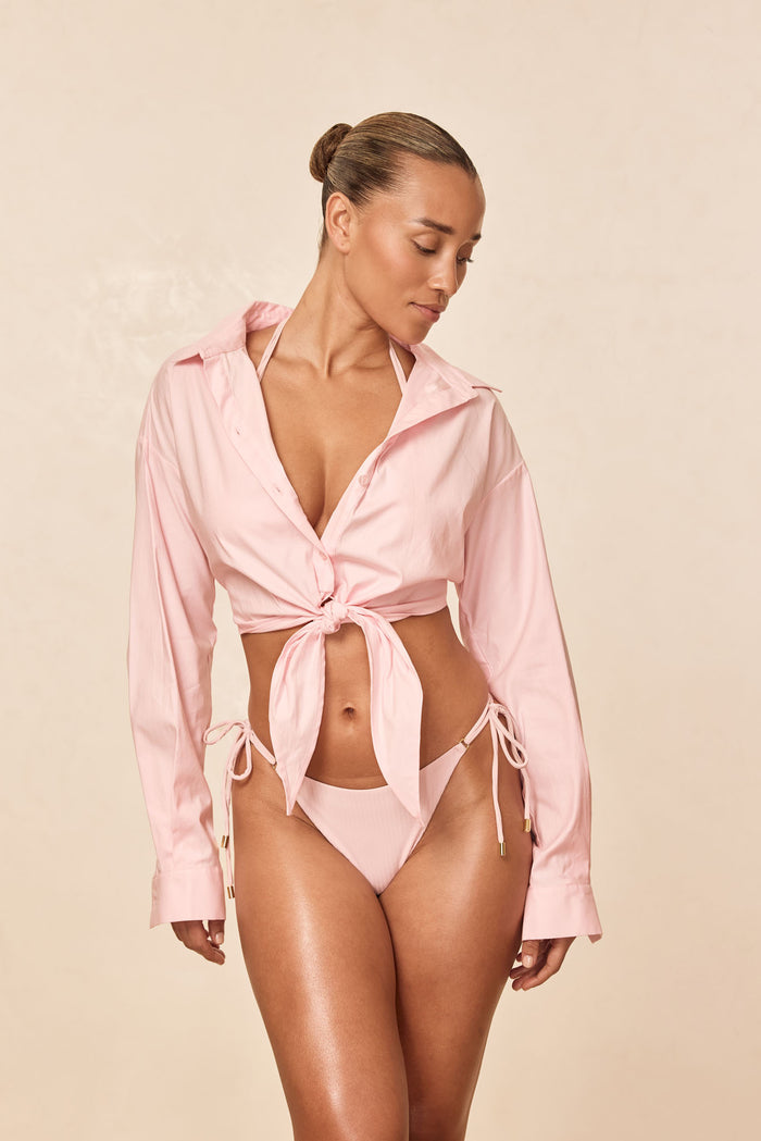 Front view of La Jolla Tie Shirt in powder pink showcasing cropped tie-front, long sleeves, open collar on model against neutral background