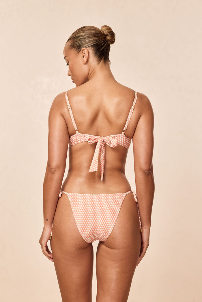 Back view of Le Marais Bottom, peach micro-geo print, cheeky coverage with adjustable side ties on neutral background