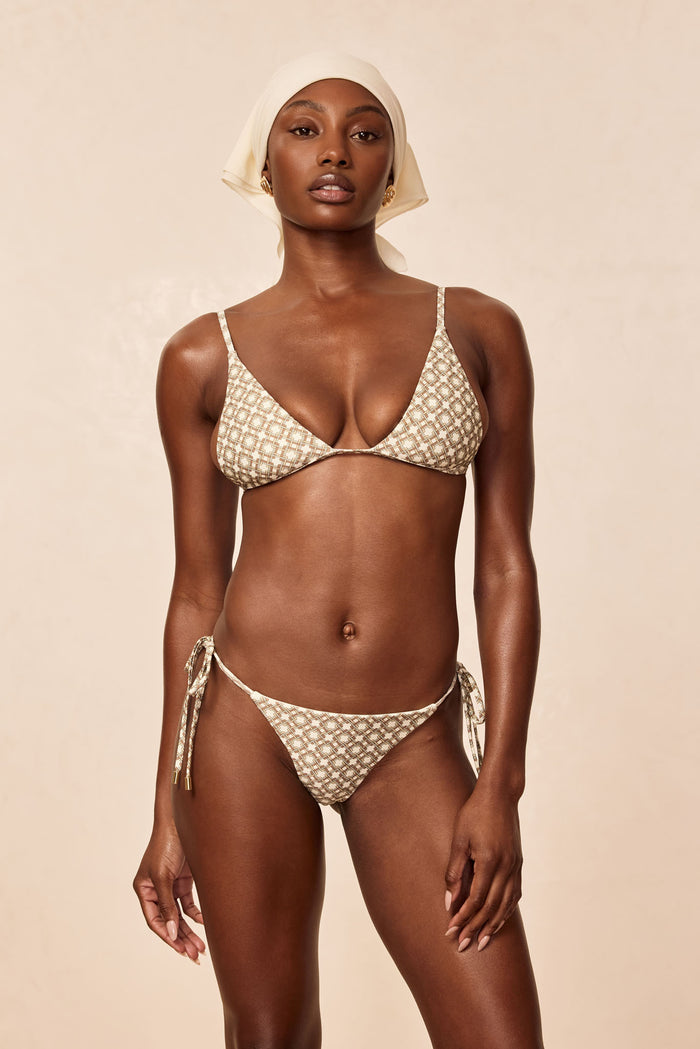 Front view of Le Marais tie-side bikini bottom in Tile Geo print showing low-rise cut and side ties on beige background