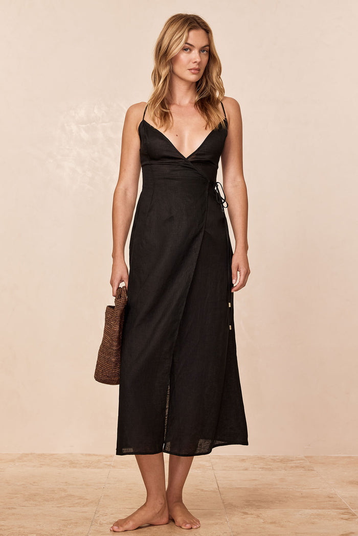Front view of Levanzo Dress in black linen, V-neck wrap, thin straps, side tie, midi length on neutral background