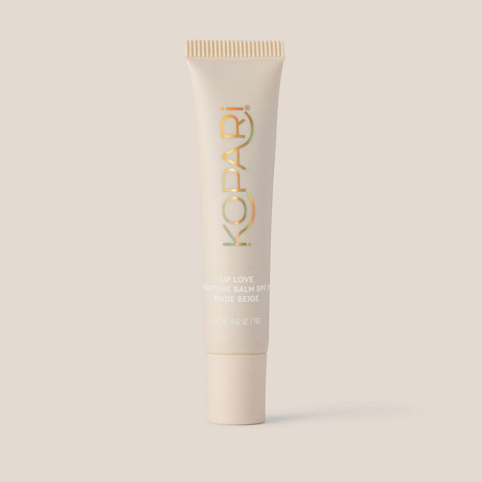 Front view of Kopari Lip Love Moisture Balm tube in Nude Beige showing SPF 30 label on solid beige background