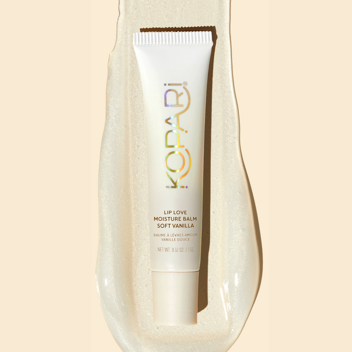 Top-down view of Lip Love Moisture Balm tube Soft Vanilla showing pearlescent shimmer on a glossy balm smear