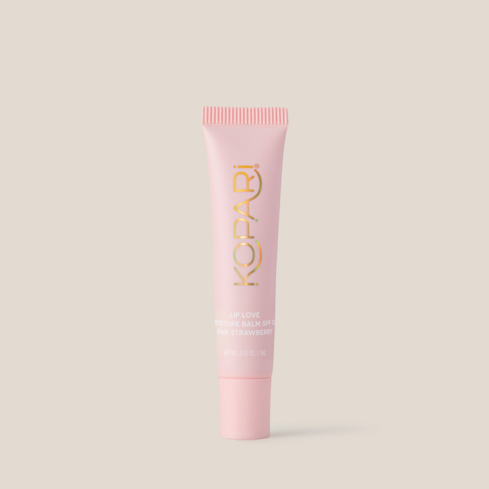 Front view of Lip Love Moisture Balm tube showing pink strawberry shade, gold Kopari logo, and SPF 30 label on a light beige background