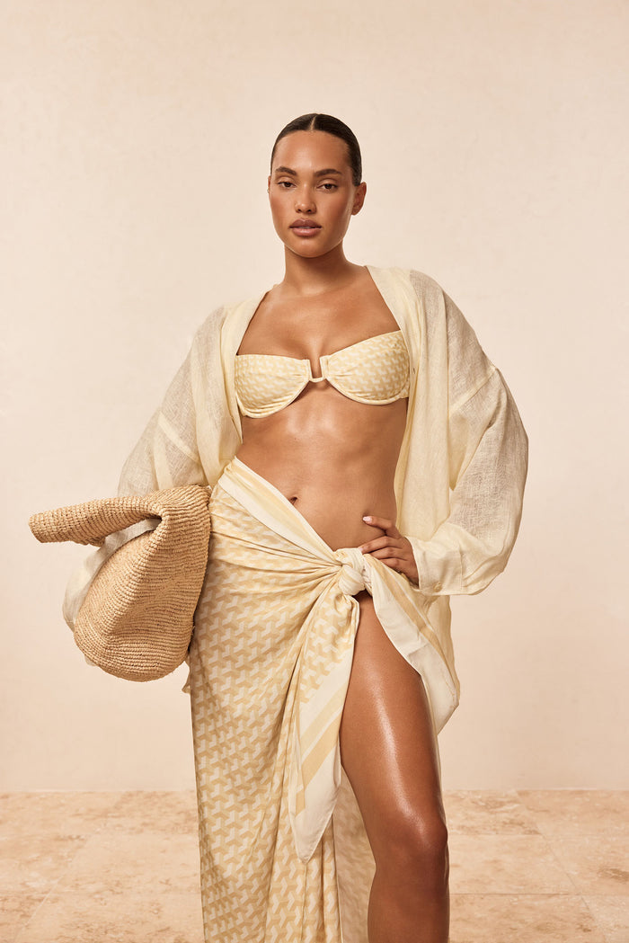 Front view of Marina Piccola Sarong Ivory Geo tied at the hip showing side slit and geometric print on neutral background
