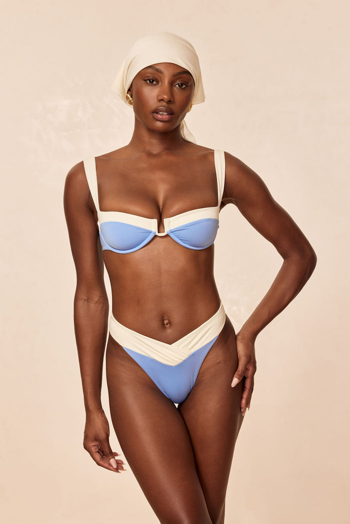 Front view of Cala Roja Top in azure and ivory on model showcasing underwire balconette shape, wide straps, and contrast ivory banding