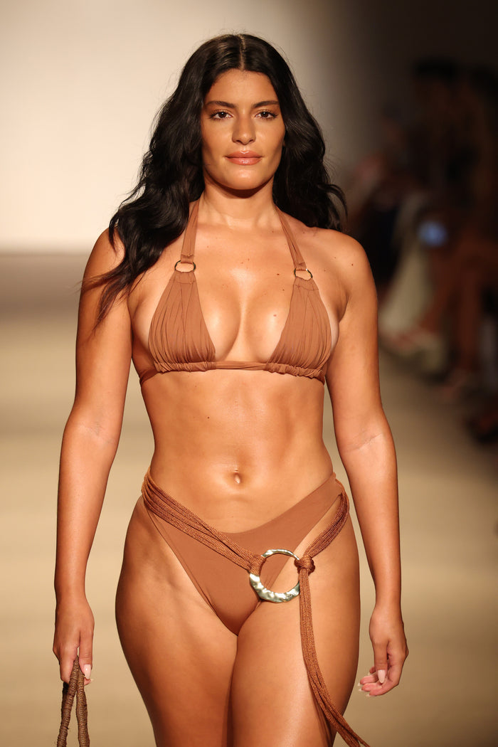 Front view of Marseille bottom in caramel on model showcasing high-cut fit, wrap tie and hammered gold-ring detail on runway