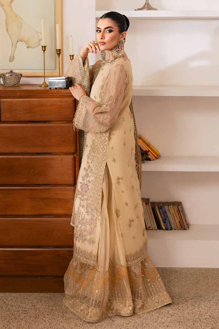 Model wearing NAQSHI Marve seated, highlighting shirt’s embroidered neckline, crystal tassels, star motifs, contrasted by sharara and draped dupatta.