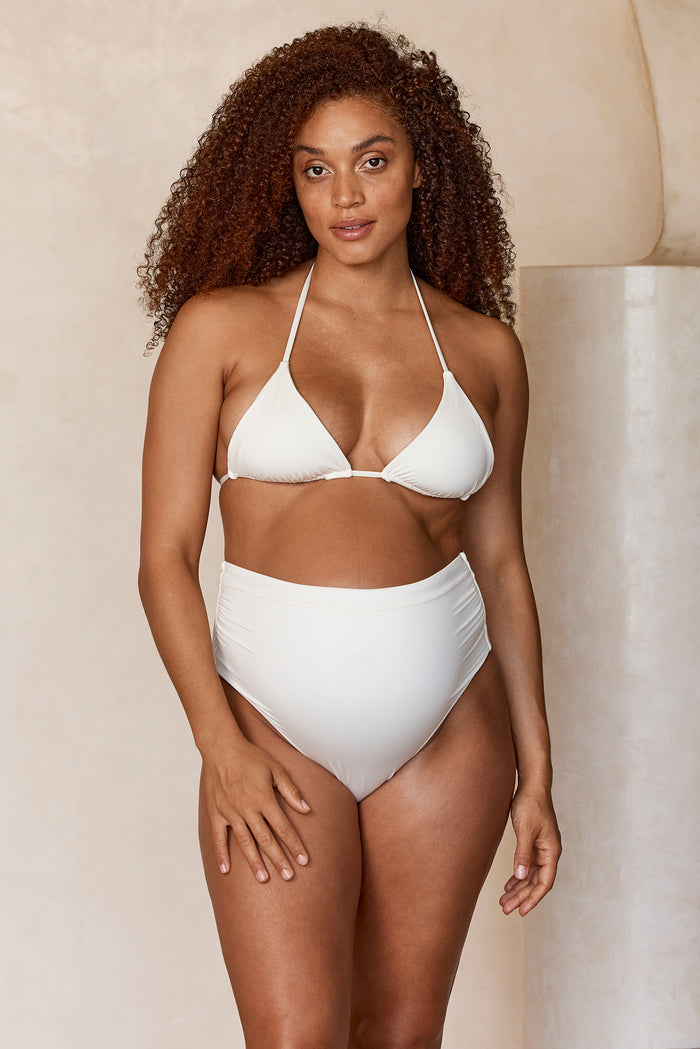 Front view of Maternity Riviera Bottom in Ivory on a pregnant model, showcasing high‑rise maternity coverage and ruched sides