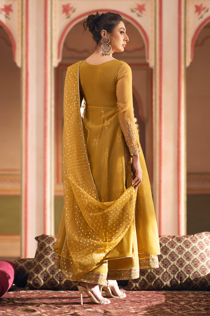 Rear view of mustard organza frock highlighting A-line silhouette and embroidery extending on the back.