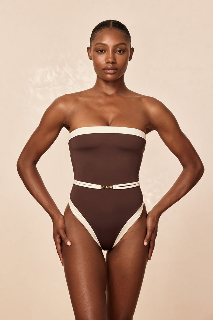Front view of Miami One Piece in espresso and ivory on model, strapless bandeau with high-cut leg and MONDAY belt