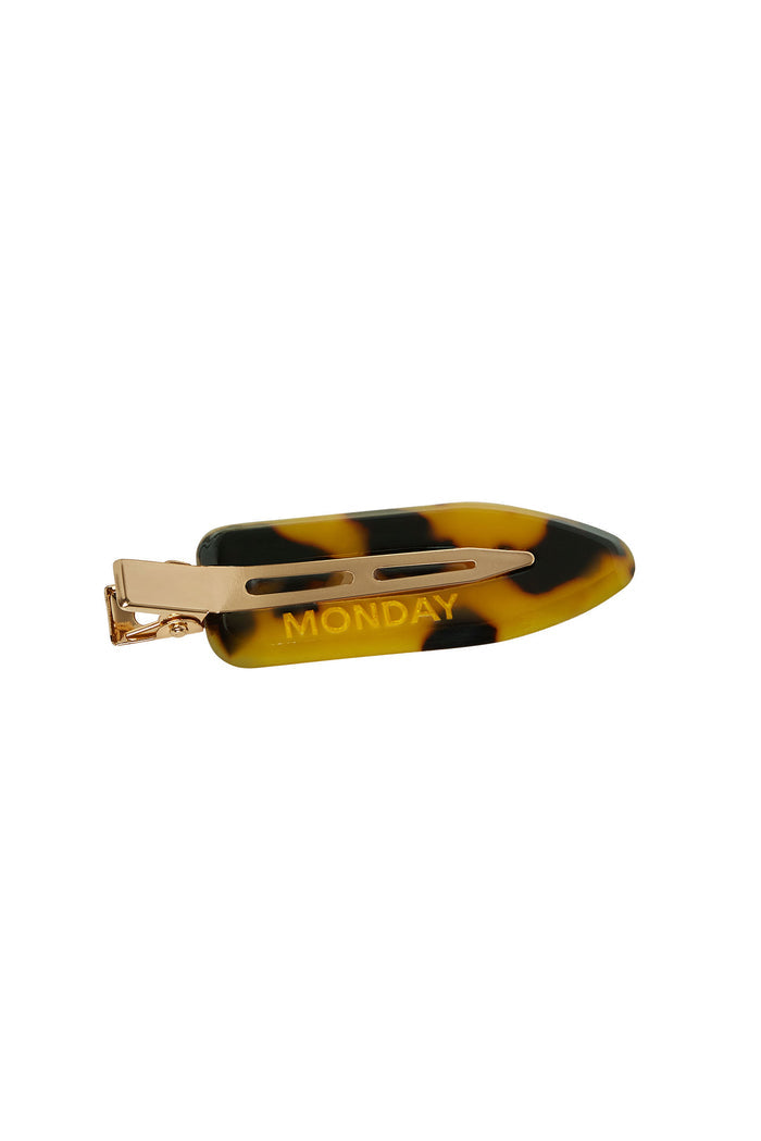 Tortoiseshell-pattern hair barrette with gold metal clip and embossed text "MONDAY"