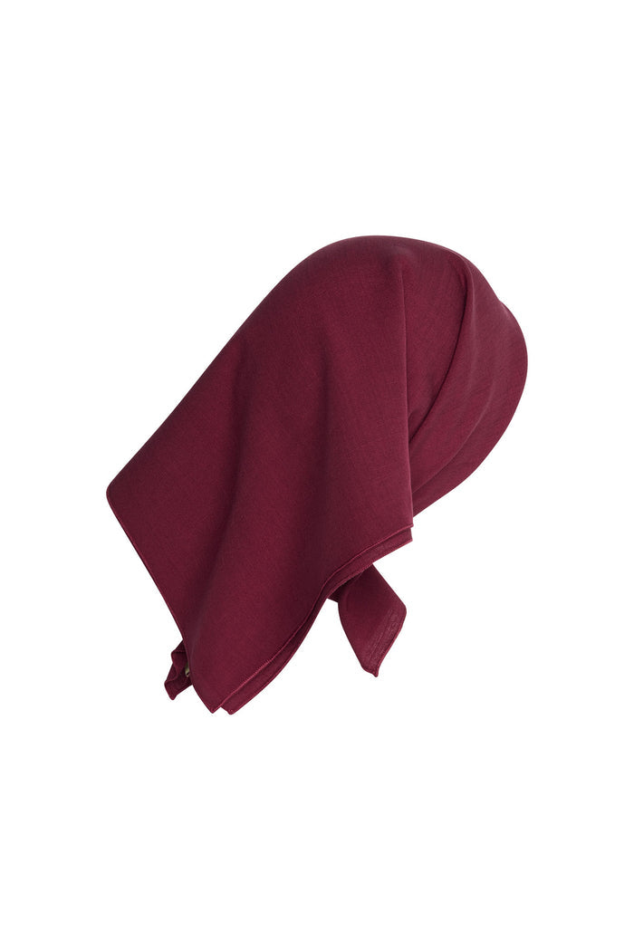 Side view of Monday Headscarf in fig styled on a head form showing square shape and smooth lightweight drape on white background