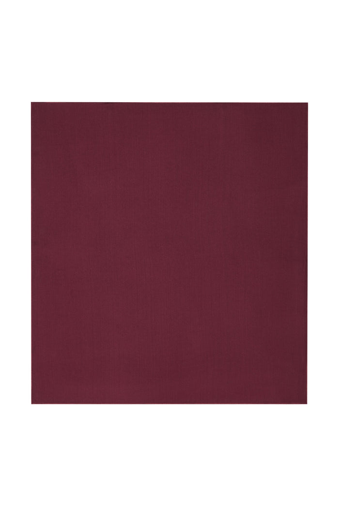 Flat lay of Monday Headscarf in Fig, a solid square rayon scarf on white background