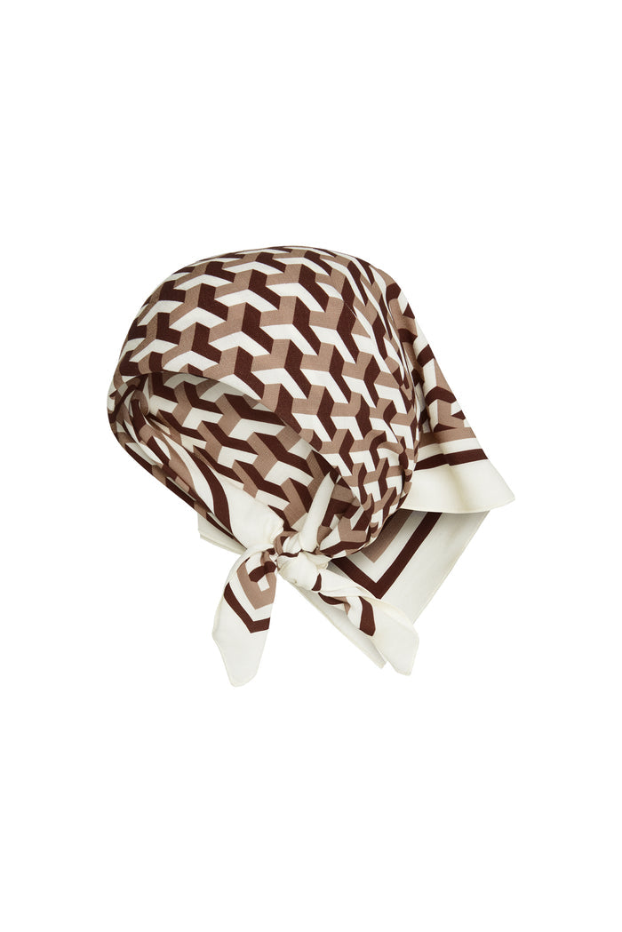 Three-quarter view of Monday Head Scarf in Husk Geo showcasing brown and cream geometric print tied at the back on a white background