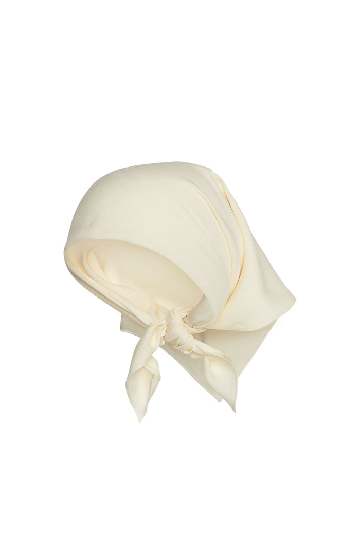 angled view of Monday headscarf in ivory rayon tied in a front knot on white background