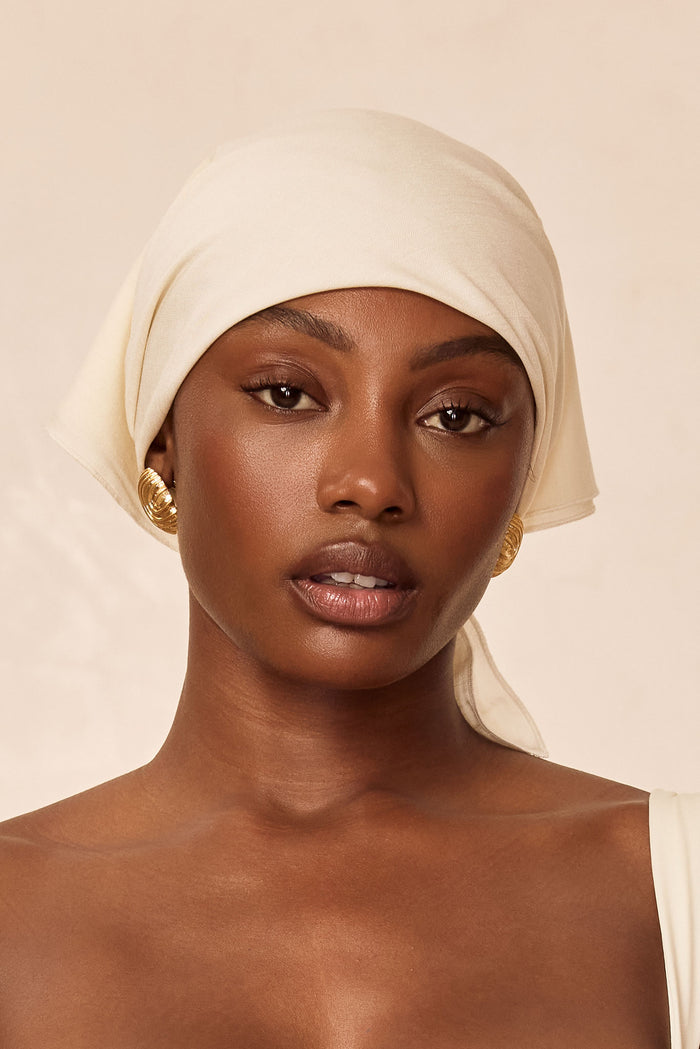 Close-up front view of Monday Headscarf in ivory showcasing soft rayon drape tied as a headscarf with neutral beige background