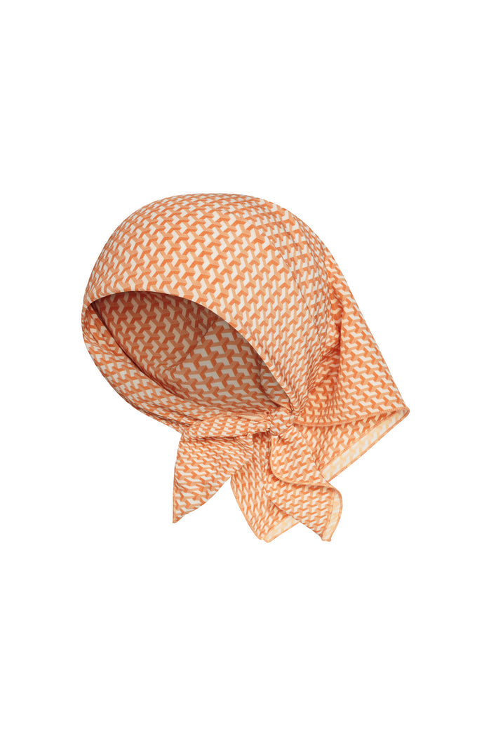 Front view of Monday Head Scarf in Micro Geo silk showing orange micro-geo print and tied knot on white background