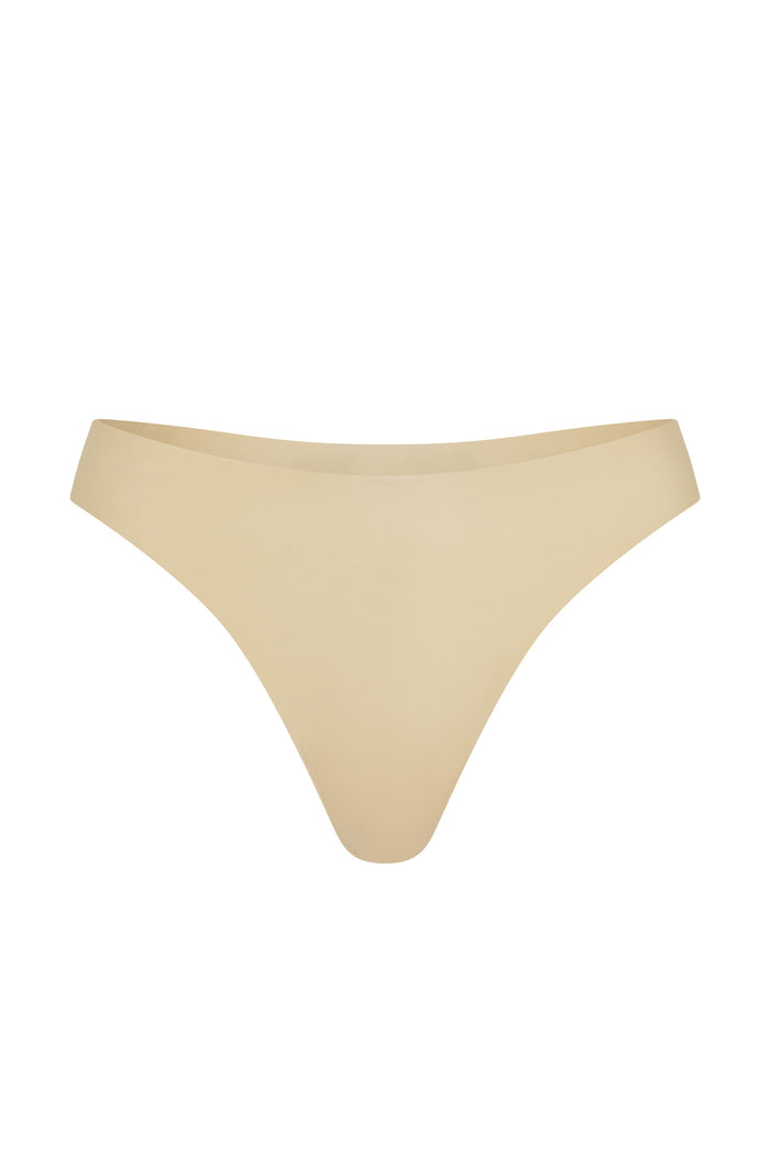 Front view of Invisible Thong in Cashmere showing mid-rise thong with raw-edge seamless finish on white background