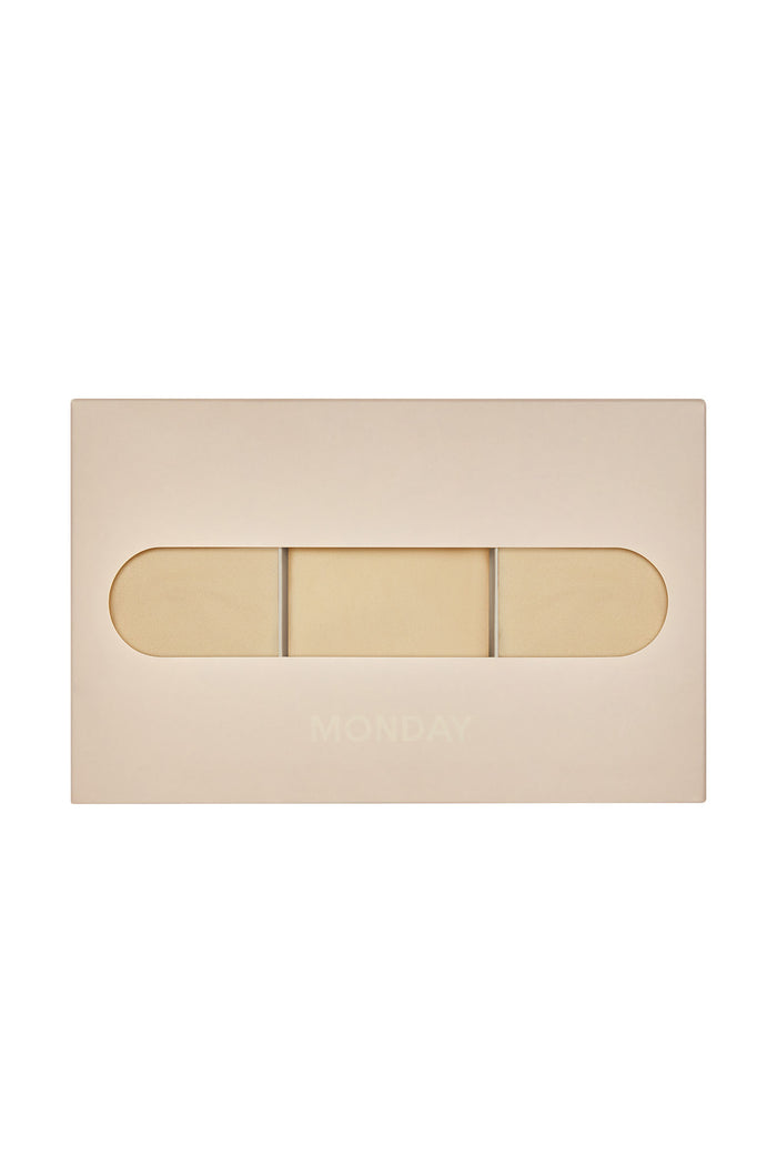Packaged Monday Invisible Thong 3-pack in cashmere showing three raw-edge thongs through box window on white background