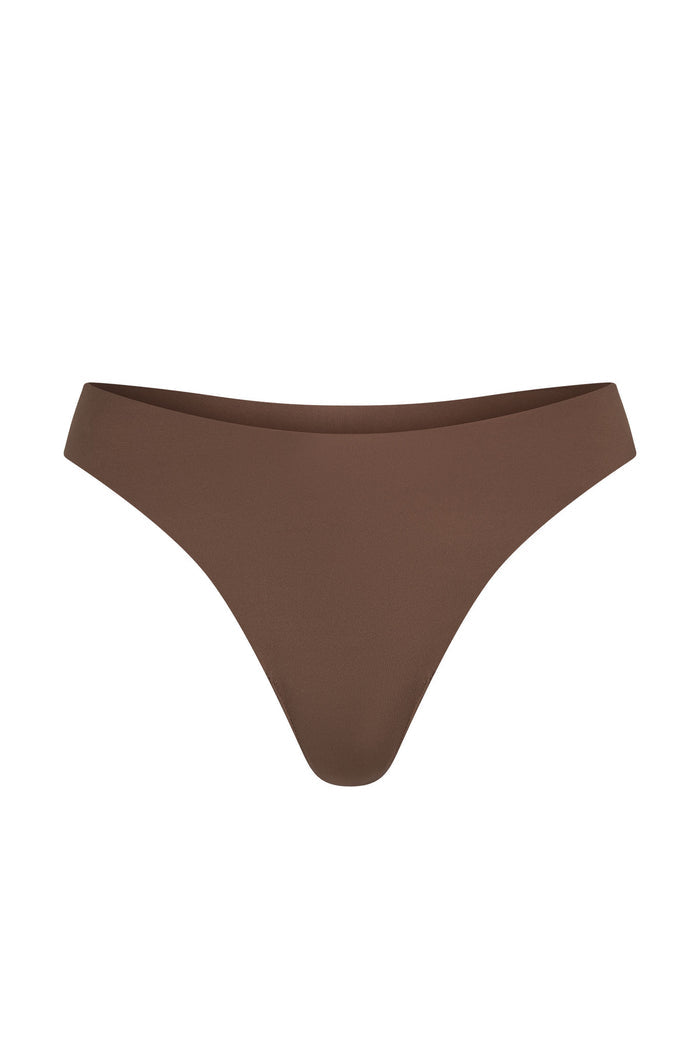 Front view of Monday Invisible Thong in mocha showcasing mid-rise cut and raw-edge seamless finish on white background