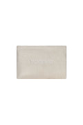 Front view of Monday Sunscreen Bag showing ivory terry exterior, tonal MONDAY embroidery, and gold zipper on white background