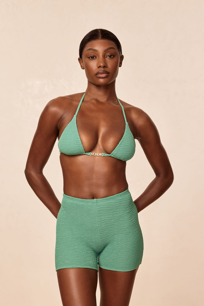 Front view of Monday Top in Pond Crinkle, triangle cups with gold MONDAY hardware on model against beige background