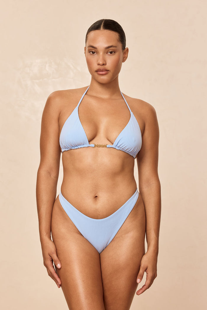 Front of Monday Top in Sky Rib showing ribbed triangle cups, gold center clasp and halter ties on beige background