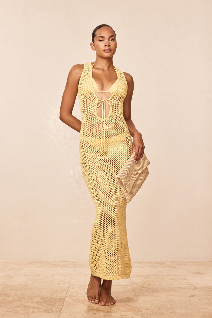 Front view of Monte Carlo Tie Dress in yellow crochet, showing plunging tie-front and semi-sheer knit on model