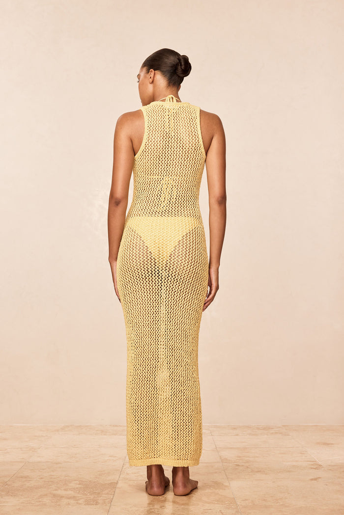 Back view of Monte Carlo Tie Dress - Meyer Petit Crochet showing sleeveless, semi-sheer petit crochet knit and adjustable neck tie on neutral background