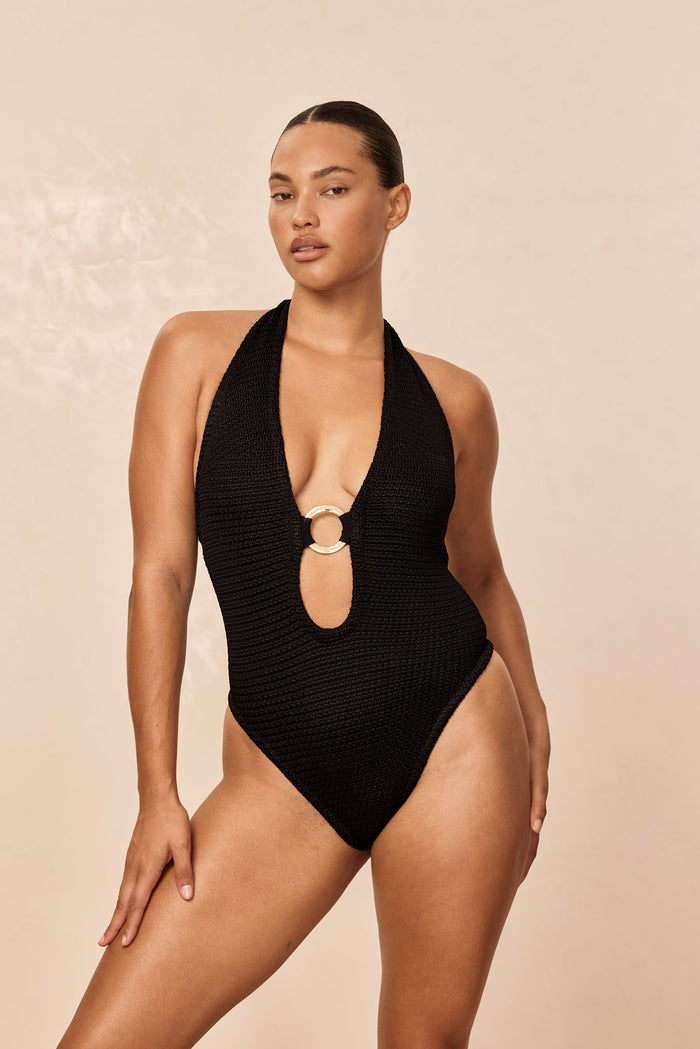 Front view of Montego bodysuit, black treble knit, showing plunging halter with gold center ring and high-cut leg