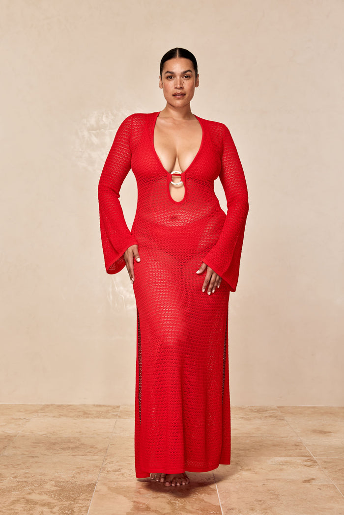 Front view of Montego Dress in Chili Pepper showcasing plunging V-neck with gold ring, bell sleeves and side slit on tile