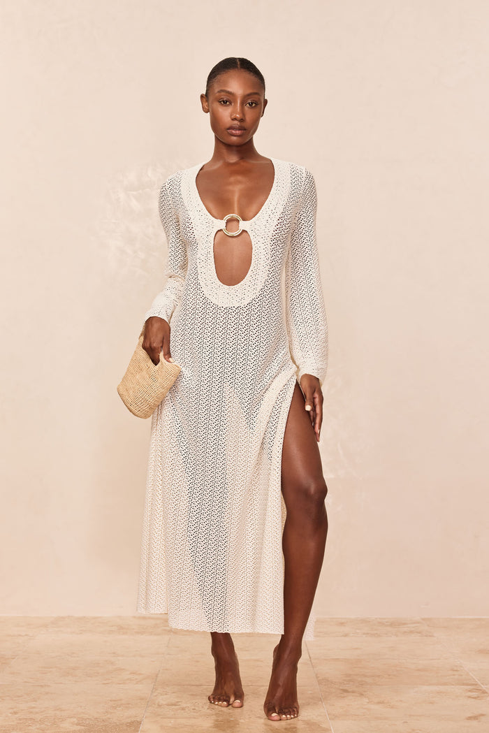 Front view of Montego Dress in ivory crochet showcasing ring-front keyhole, long sleeves, side slit, open knit on beige backdrop
