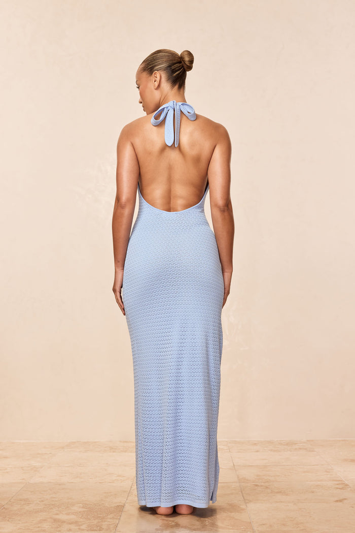 Back view of Montego Halter Dress in sky lace crochet with low back, halter tie, and textured knit on beige background