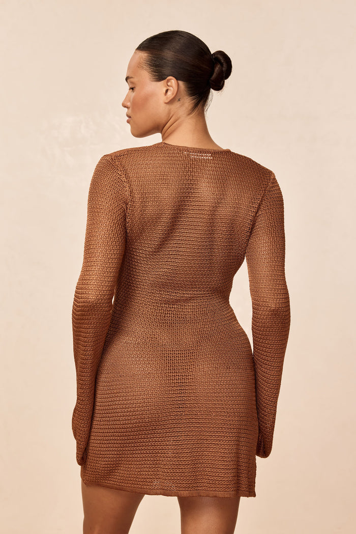 Rear view of Montego Mini Dress in caramel treble knit showing open-knit texture, long sleeves, and fitted silhouette on neutral background