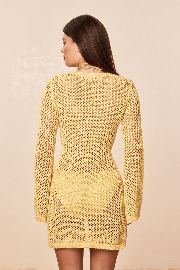 Rear view of Montego Mini Dress Meyer Petit Crochet showcasing open crochet knit, long flared sleeves and sheer unlined fit