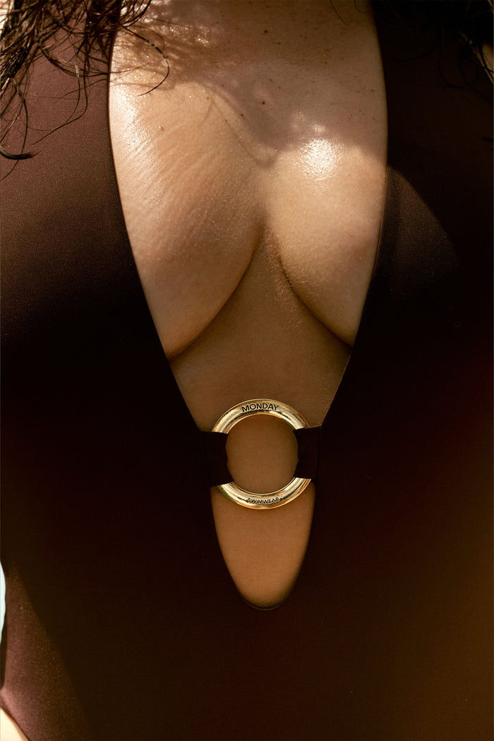 Front close-up of Montego One Piece in Espresso showing deep halter V neckline and gold ring stamped MONDAY SWIMWEAR