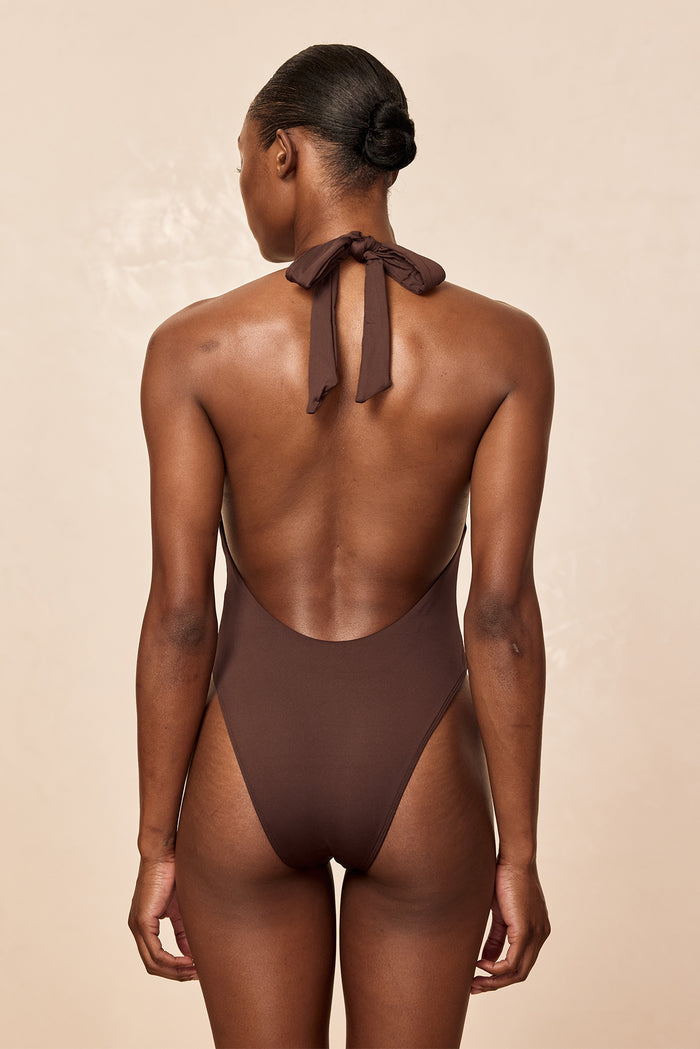 Back view of Montego One Piece in Espresso showcasing halter tie at the nape and low scoop back against a beige backdrop