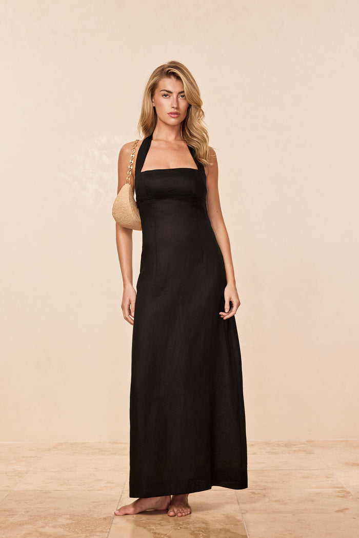 Front view of Montserrat black linen dress on model, fitted square bodice, halter straps and long straight skirt