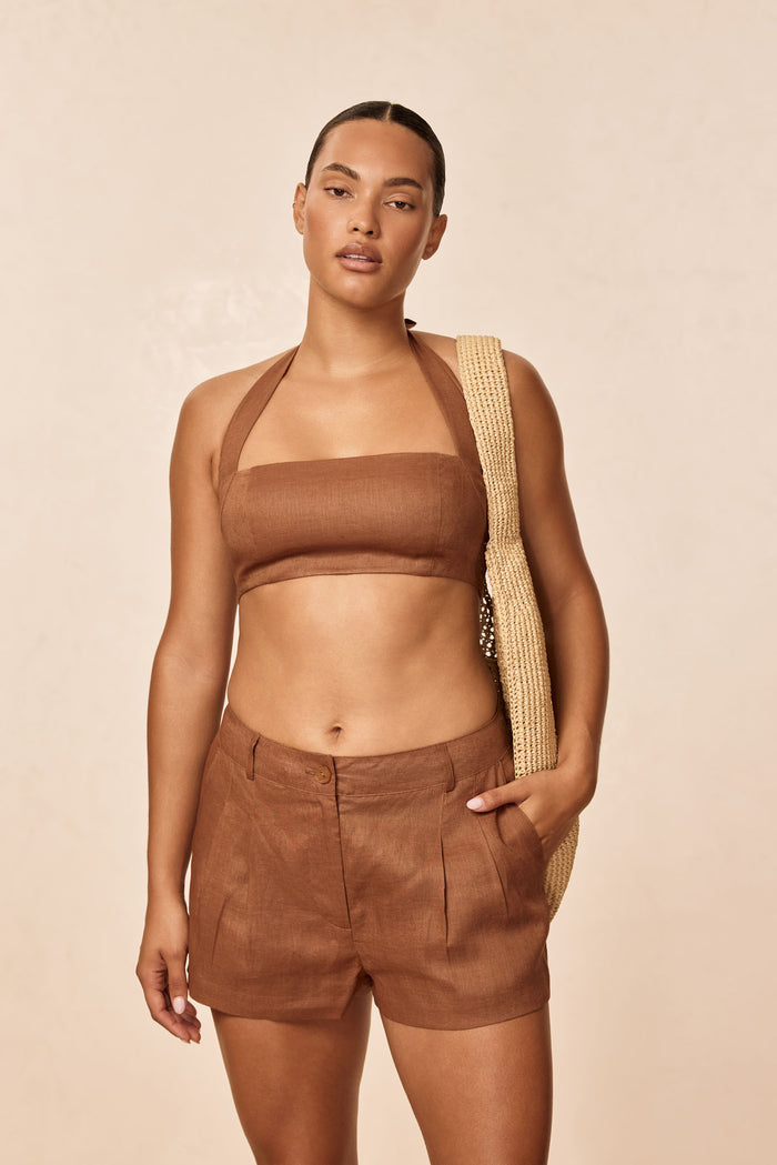 Front view of Montserrat top in caramel linen showing square bandeau, halter straps and cropped fit on model, beige background