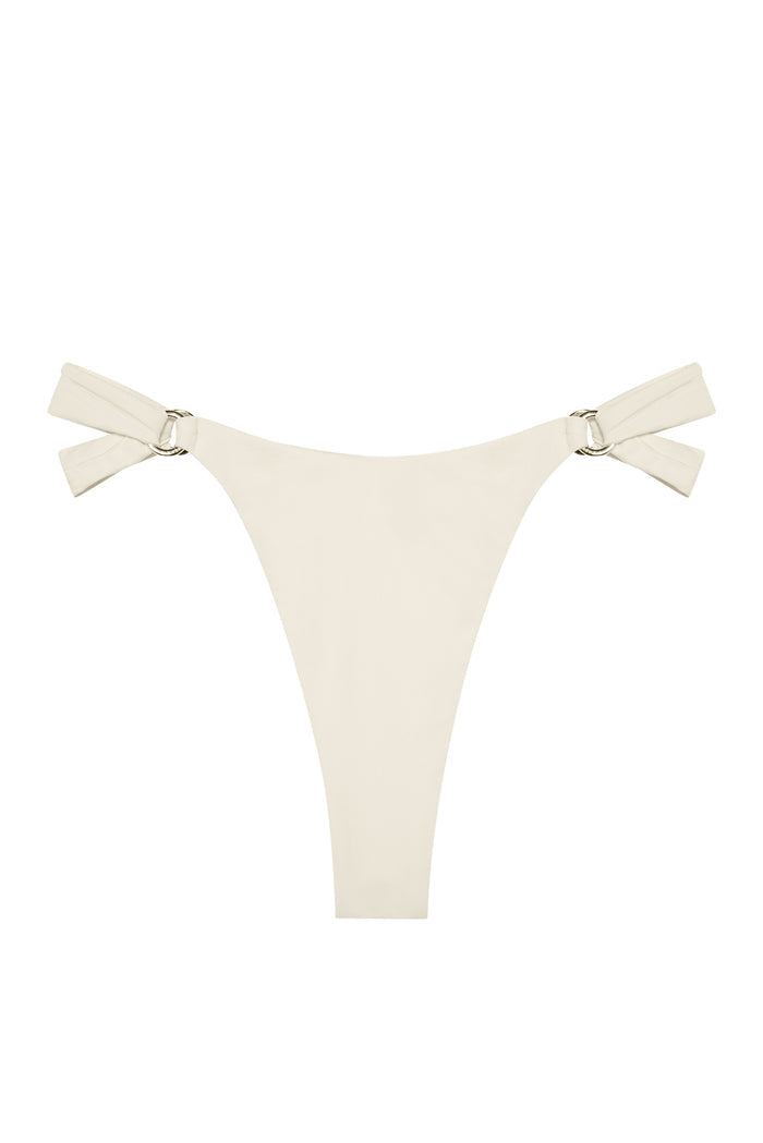 Flat lay of Morocco Bottom in Ivory showcasing high-cut silhouette, side tie straps and gold ring hardware on white