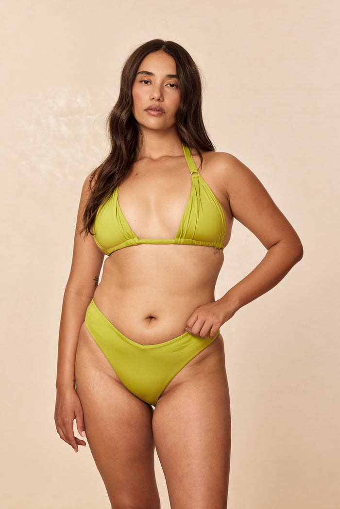Front view of St. Lucia Bottom in Apple on model showing high-leg V-front mid-rise and cheeky coverage on neutral background