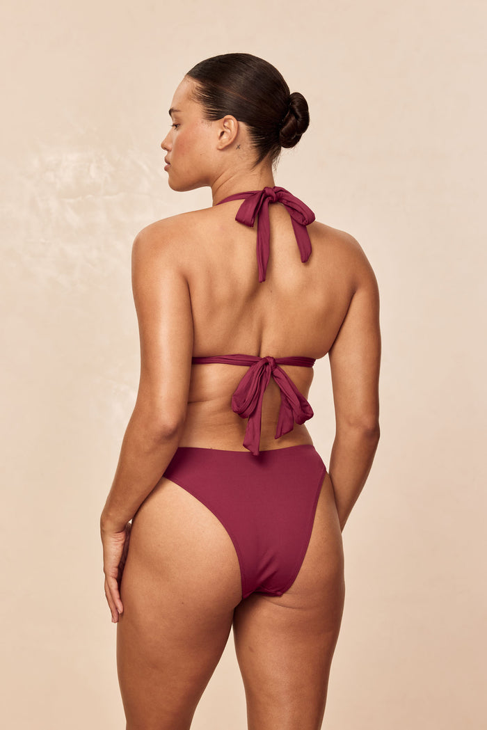 Rear view of Tamarama bottom in fig on model showcasing high cut leg and moderate coverage with neutral beige background